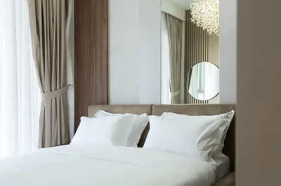 a bedroom with a bed with white pillows and a mirror at KeyRock - Grand Bleu Escape with Iconic Palm Views in Dubai