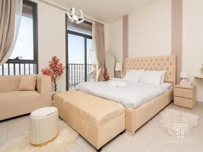 a bedroom with a large bed and a couch at Brand New High Floor Studio in Midtown Dubai in Dubai