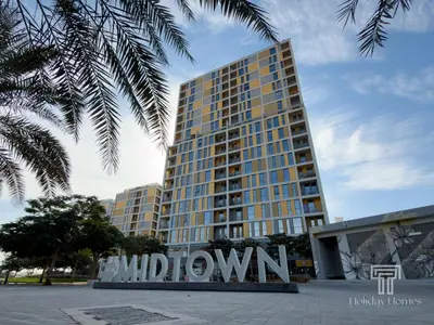 a tall building with a sign in front of it at Brand New High Floor Studio in Midtown Dubai in Dubai