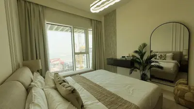 a bedroom with a large bed and a large window at Elegant Seaside Luxury 1BR in Beachfront, Grand BLeu Tower, Pool & Gym in Dubai