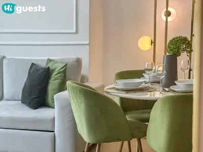 a dining room with a table and green chairs at HiGuests - Marina View 1 BR with Spacious Balcony in Dubai