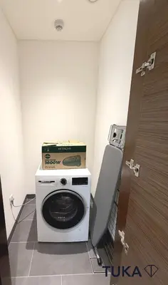 a washing machine with a box on top of it in a room at Lux - 2BR - Spacious - Burj Khalifa View - New Bld in Dubai