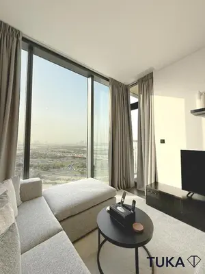 a living room with a couch and a large window at Lux - 2BR - Spacious - Burj Khalifa View - New Bld in Dubai