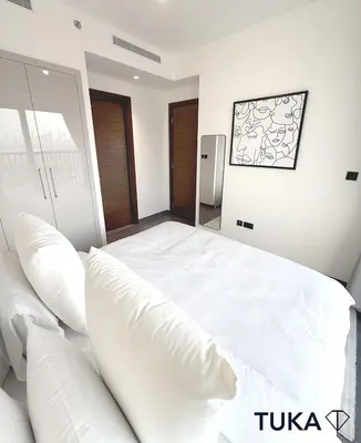 a bedroom with a large white bed with pillows at Lux - 2BR - Spacious - Burj Khalifa View - New Bld in Dubai