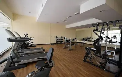 a gym with treadmills and machines in a room at Lovely Studio with balcony in Silicon Oasis in Dubai