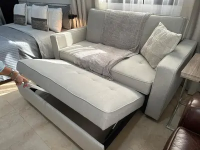 a couch sitting next to a bed in a room at Lovely Studio with balcony in Silicon Oasis in Dubai