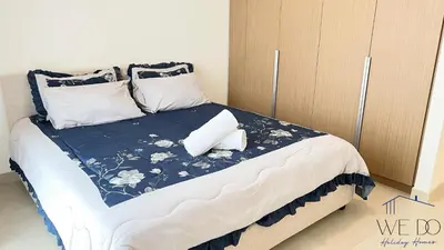 a bedroom with a bed with a blue and white comforter at Luxury Apartment in CREEK Harbour in Dubai