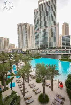 a pool with palm trees and chairs in a city at Luxury Apartment in CREEK Harbour in Dubai