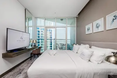 a bedroom with a large bed and a flat screen tv at Studio Apartments with City View at DAMAC Maison Prive in Dubai