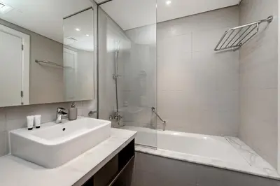 a white bathroom with a sink and a tub at Studio Apartments with City View at DAMAC Maison Prive in Dubai