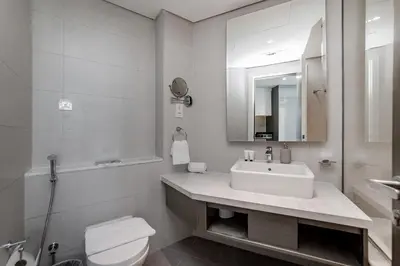a bathroom with a sink and a toilet and a mirror at Studio Apartments with City View at DAMAC Maison Prive in Dubai