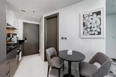 a kitchen and dining room with a table and chairs at Studio Apartments with City View at DAMAC Maison Prive in Dubai