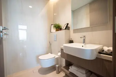 a bathroom with a white sink and a toilet at Hububb Luxury Peninsula 5 Dubai in Dubai