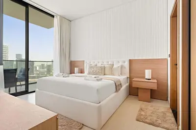 a bedroom with a white bed and a large window at Silkhaus Modern 1BDR Stay in JVC in Dubai