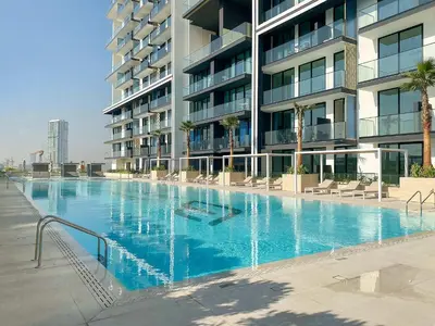 a large swimming pool in front of a building at Silkhaus Modern 1BDR Stay in JVC in Dubai
