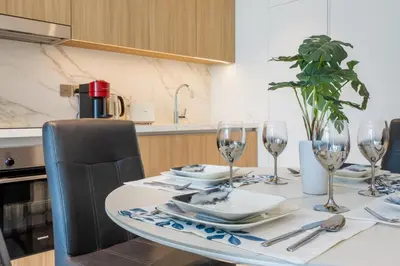a dining room table with wine glasses on it at Beach Vista - One Bed with Infinity Pool Access in Dubai