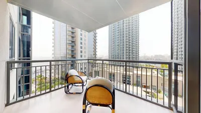 two chairs on a balcony with views of buildings at Creek Residences - Opulent Two Bed with Creek View in Dubai