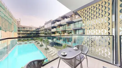 a balcony with a swimming pool and a table and chairs at Binghatti Crescent - Two Bed with Pool View in JVC in Dubai