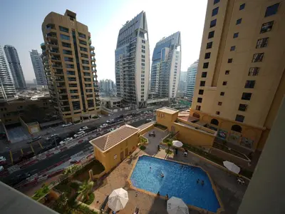 an aerial view of a city with buildings and a pool at Happyland JBR Dubai Hostel in Dubai