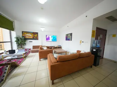 a living room with two couches and a table at Happyland JBR Dubai Hostel in Dubai