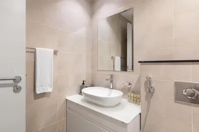 a bathroom with a white sink and a mirror at Maison Privee - Stylish Studio with Top Facilities in Damac Hills in Dubai