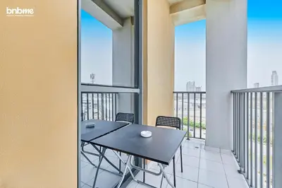 a dining room with a table and chairs and windows at bnbmehomes - Afnan 4 - Midtown in Dubai