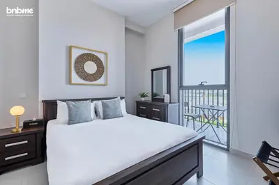 a bedroom with a large bed and a balcony at bnbmehomes - Afnan 4 - Midtown in Dubai