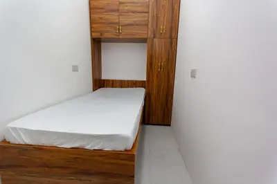 a small bedroom with a bed and a cabinet at Rental Small Rooms for female guest in the heart of Dubai بنات فقط in Dubai