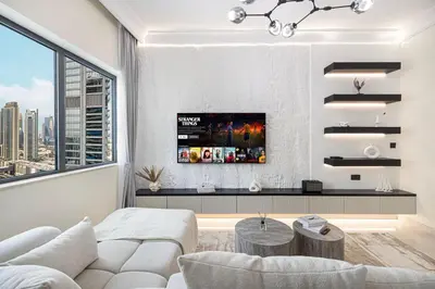 a living room with a white couch and a large window at Restay Homes at Damac Maison Mall - Full Burj View from all rooms - 1 min to Dubai Mall in Dubai