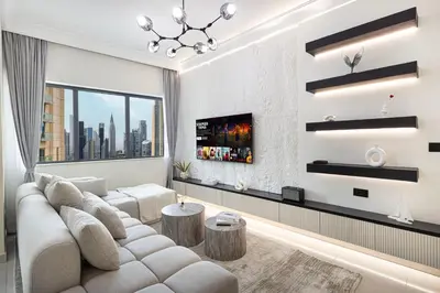 a living room with a white couch and a large window at Restay Homes at Damac Maison Mall - Full Burj View from all rooms - 1 min to Dubai Mall in Dubai