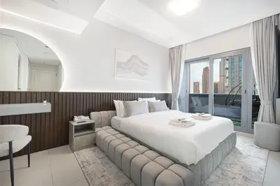 a bedroom with a large white bed and a window at Restay Homes at Damac Maison Mall - Full Burj View from all rooms - 1 min to Dubai Mall in Dubai