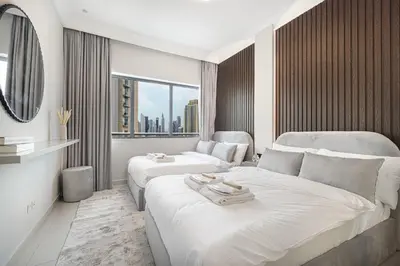 a hotel room with two beds and a large window at Restay Homes at Damac Maison Mall - Full Burj View from all rooms - 1 min to Dubai Mall in Dubai