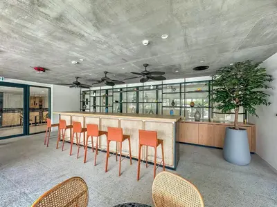 a restaurant with a bar with orange chairs at Dubai Hills Cozy 1Br Golfville in Dubai