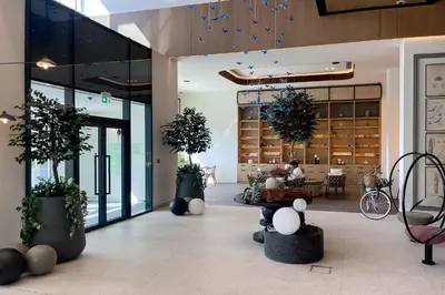 a lobby with potted plants in a building at Dubai Hills Cozy 1Br Golfville in Dubai