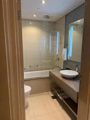 a bathroom with a sink and a tub and a toilet at 2BR Apartment in Paramount Hotel with Burj Khalifa View in Dubai