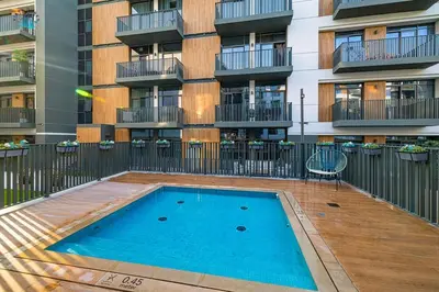 a swimming pool in front of a apartment building at Contemporary 2-BR at Belgravia Square JVC in Dubai