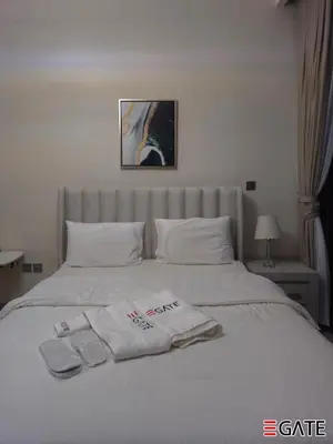 a white bed with two towels on top of it at EGATE - Studio - 4th Floor - Balcony with a View - 20-423 in Dubai