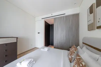 a bedroom with a bed and a dresser at Stylish Duplex Autograph 1BR in Dubai