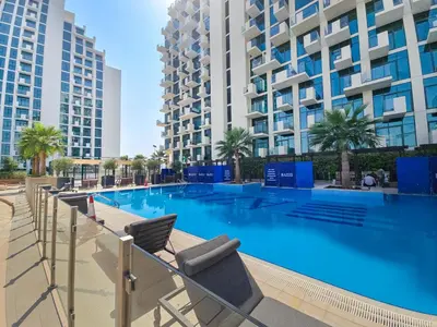 a swimming pool with chairs and buildings in the background at EasyGo- City Center, Spacious, Skyline view in Dubai