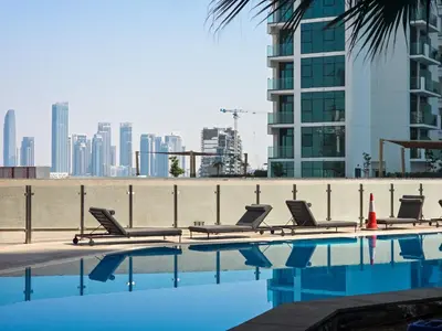 a swimming pool with lounge chairs and a city skyline at EasyGo- City Center, Spacious, Skyline view in Dubai