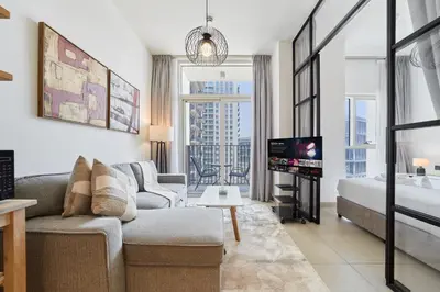 a living room with a couch and a tv at Chic & Modern 1BR in Socio Near Dubai Hills Park in Dubai