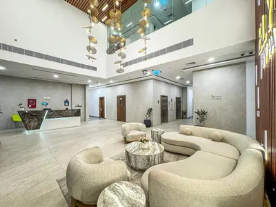 a lobby with couches and a table and chairs at Savis Homes - Luxury Brand New Studio in Elysee III in JVC in Dubai