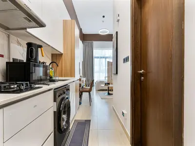 a kitchen with a washer and dryer at Savis Homes - Luxury Brand New Studio in Elysee III in JVC in Dubai