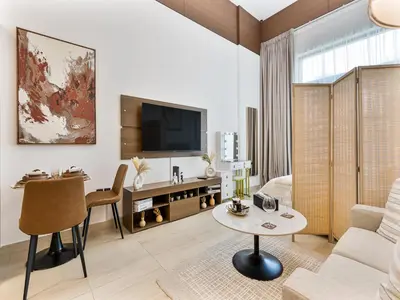 a living room with a couch and a table at Savis Homes - Luxury Brand New Studio in Elysee III in JVC in Dubai