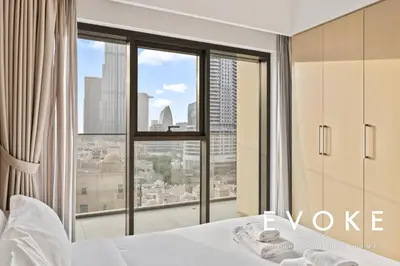a bedroom with a bed and a large window at Full Burj & Fountain View - Evoke 2BR at Burj Royale in Dubai