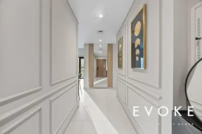 a hallway with white walls and white floors at Full Burj & Fountain View - Evoke 2BR at Burj Royale in Dubai