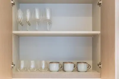 a shelf with glass vases and cups on it at New 1BR Burj view- Infinity Pool - Dubai Mall in Dubai