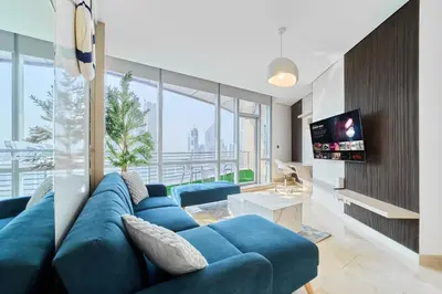a living room with a blue couch and a tv at 1BR Sky Gardens Balcony with Stunning DIFC View in Dubai