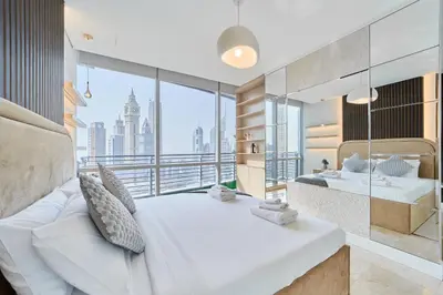 a bedroom with a large white bed and a large window at 1BR Sky Gardens Balcony with Stunning DIFC View in Dubai