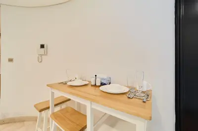 a table with plates on it in a room at 1BR Sky Gardens Balcony with Stunning DIFC View in Dubai